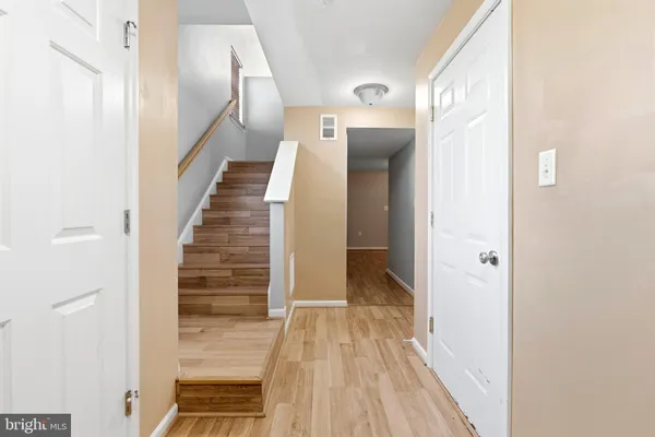 a view of a hallway with wooden floor and entryway