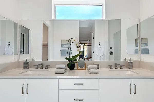 a bathroom with double sink and a mirror