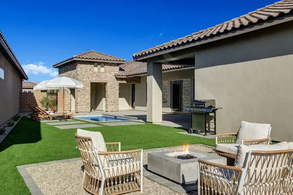 a view of a house with patio and a yard