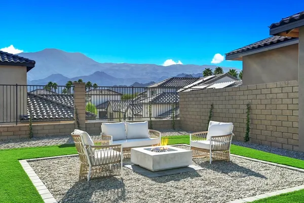 a view of a chairs and table in the back yard of the house