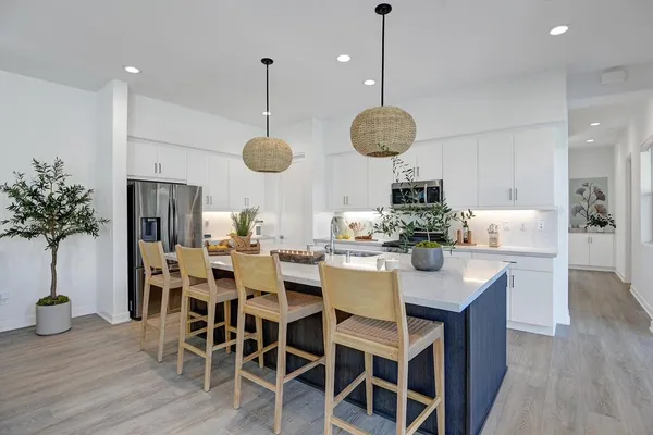 a kitchen with stainless steel appliances kitchen island a large island in the center cabinets and furniture