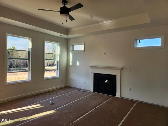 a view of an empty room with a fireplace and a window