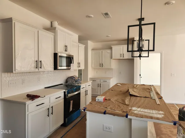 a kitchen with stainless steel appliances granite countertop a sink stove and microwave