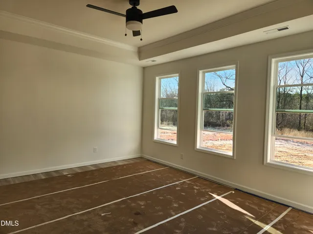 a view of a room with a large window and chandelier fan