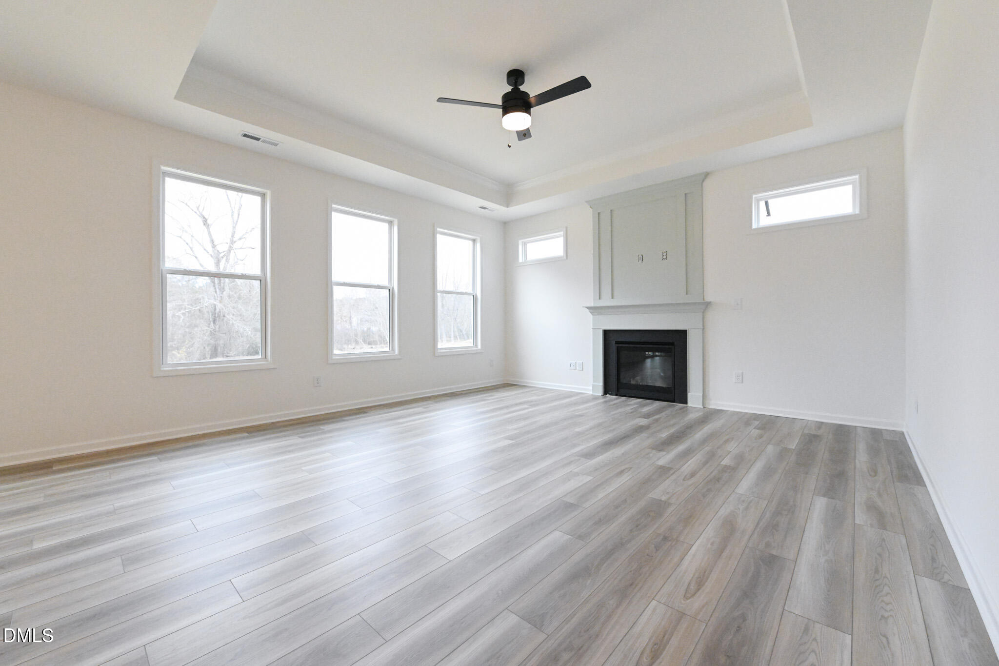 72 South Bream Court Angier, NC 27501 - Photo 10 of 44 an empty room with wooden floor ceiling fan and windows