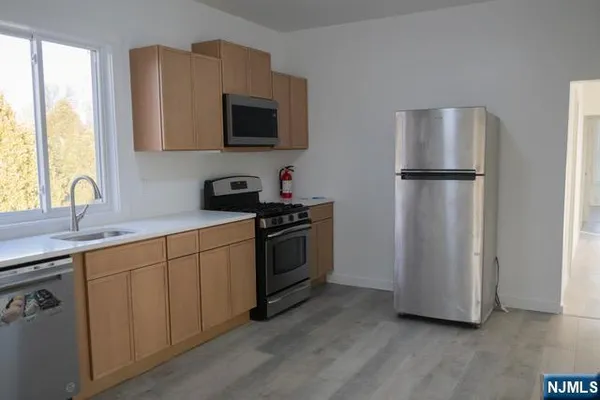 a kitchen with stainless steel appliances a refrigerator sink and microwave