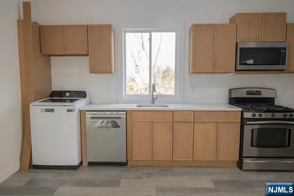 a kitchen with appliances a sink and a stove