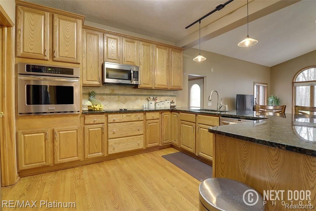 9730 Quail Ridge Run Brighton, MI 48114 - Photo 13 of 30 Gourmet Kitchen with Extra Large Walk-In Pantry, Granite Countertops and Stainless Appliances