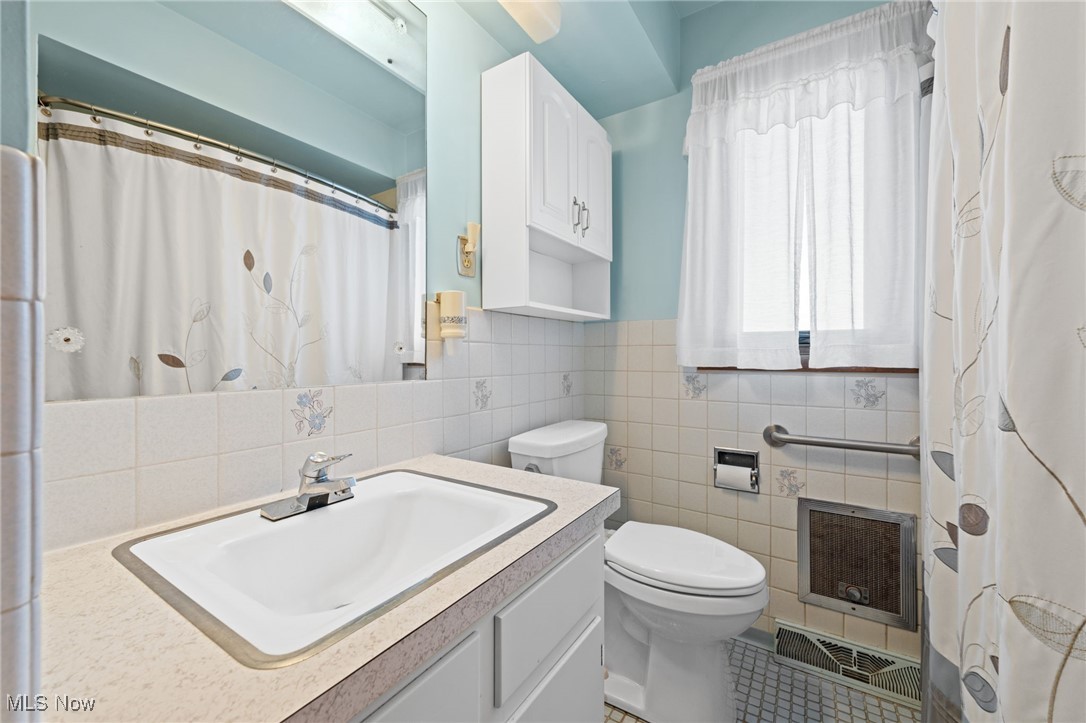 586 Bishop Road Cleveland, OH 44143 - Photo 13 of 24 Full bath with visible vents, toilet, heating unit, vanity, and tile walls