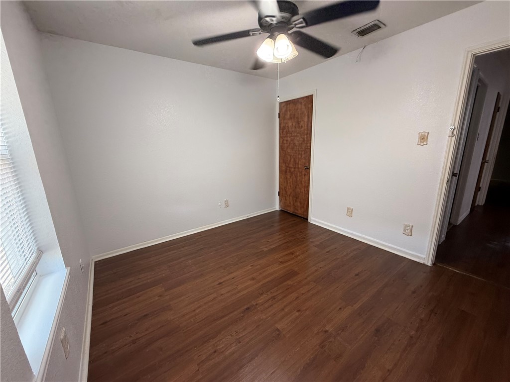 902 St Timothy Street Corpus Christi, TX 78418 - Photo 10 of 24 an empty room with wooden floor fan and window