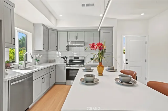 a kitchen with stainless steel appliances kitchen island granite countertop a sink and cabinets