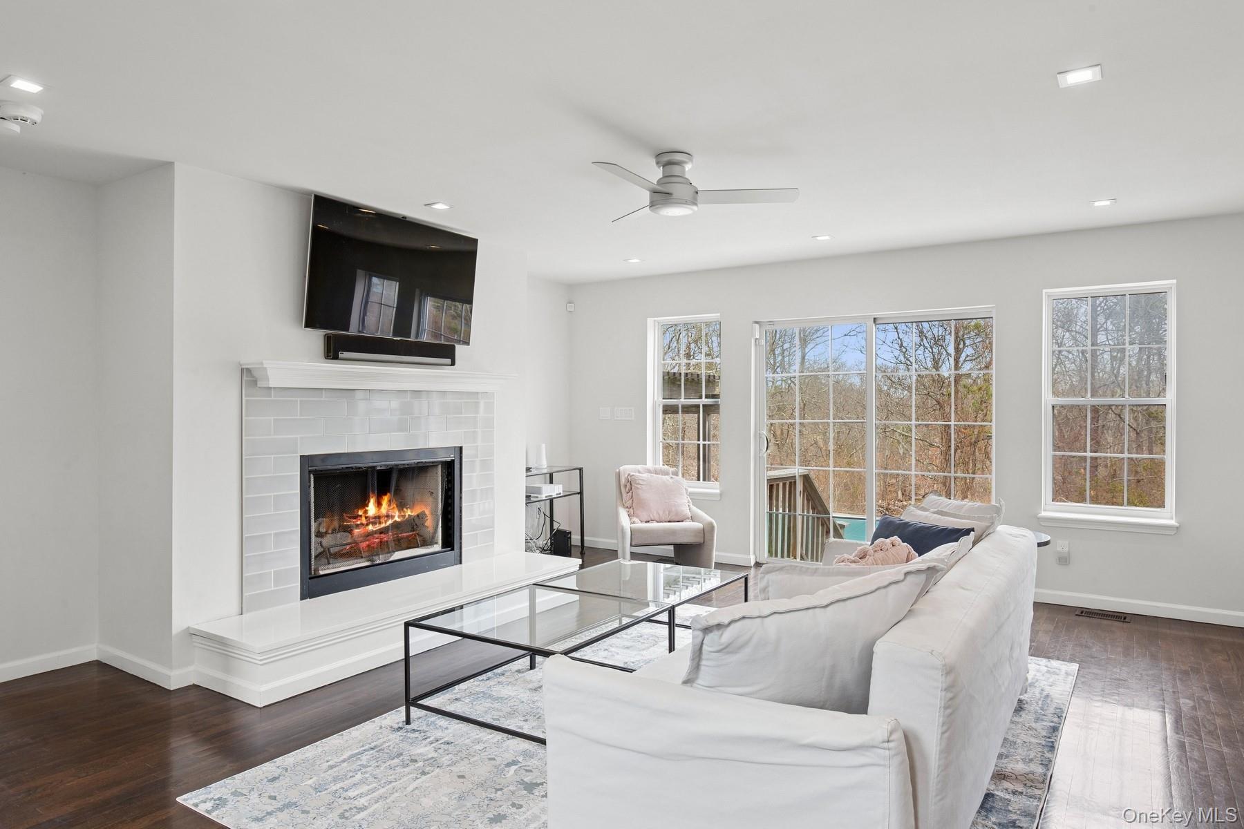 71 Old Canoe Place Road Hampton Bays, NY 11946 - Photo 12 of 34 a living room with furniture a flat screen tv and a fireplace