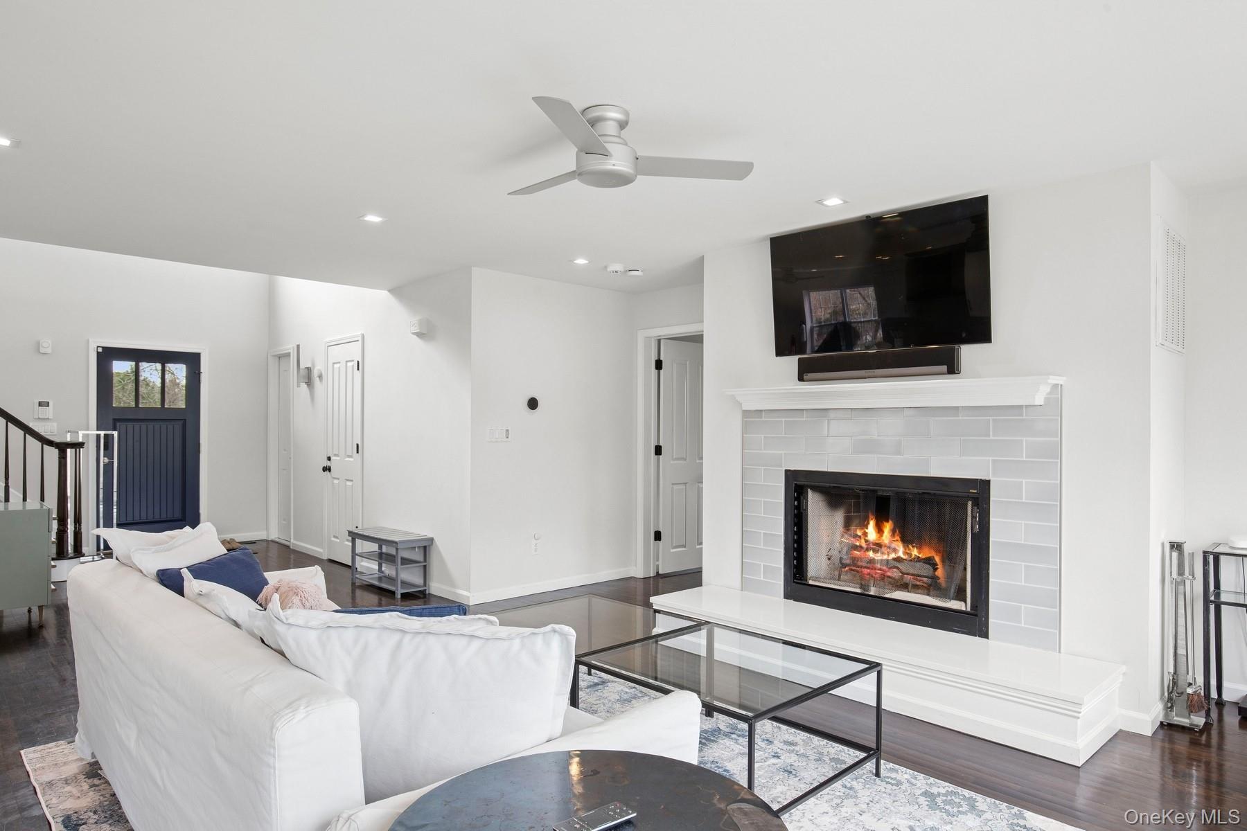 71 Old Canoe Place Road Hampton Bays, NY 11946 - Photo 13 of 34 a living room with furniture a flat screen tv and a fireplace