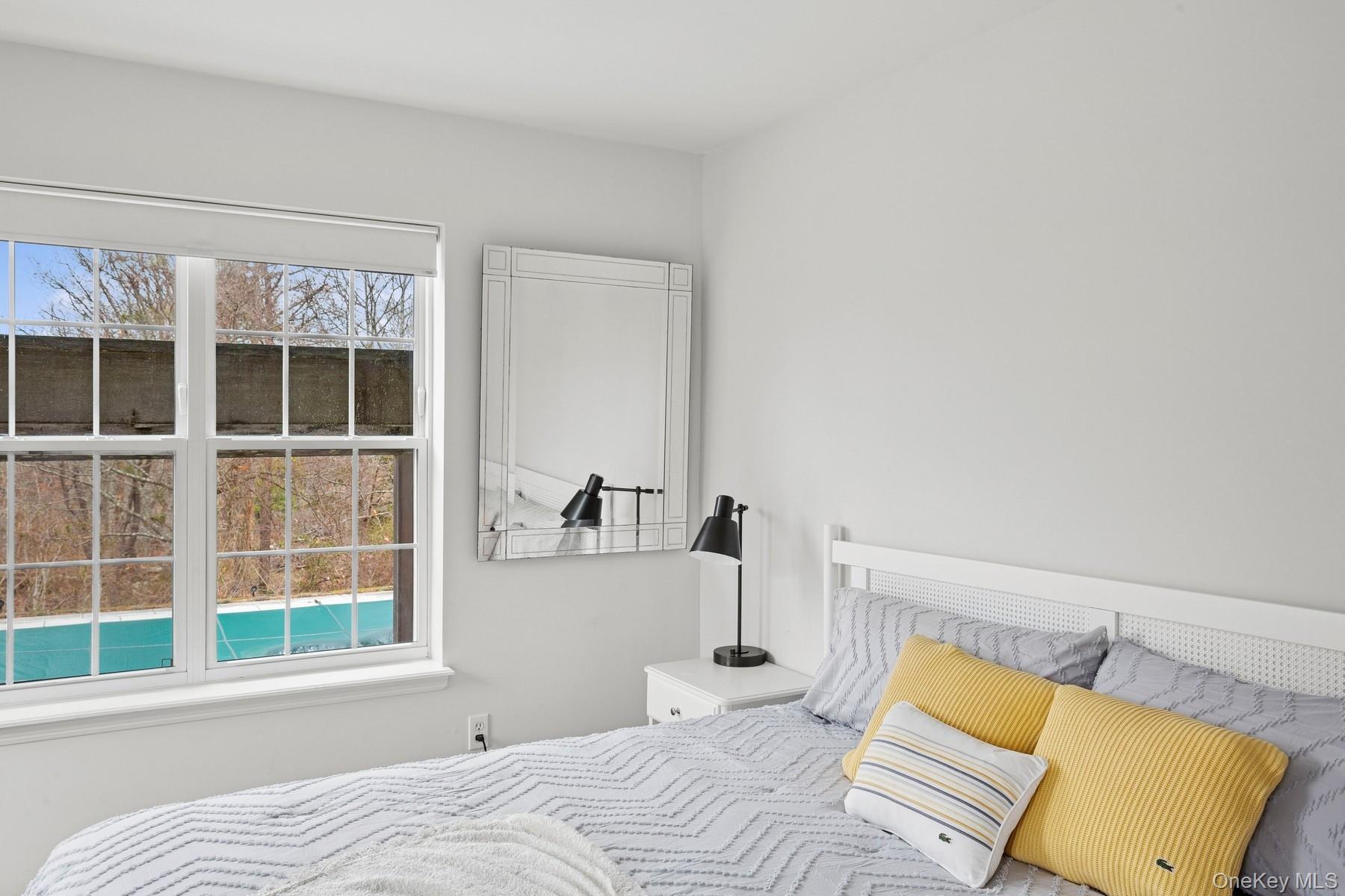 71 Old Canoe Place Road Hampton Bays, NY 11946 - Photo 15 of 34 a bedroom with a bed and a window