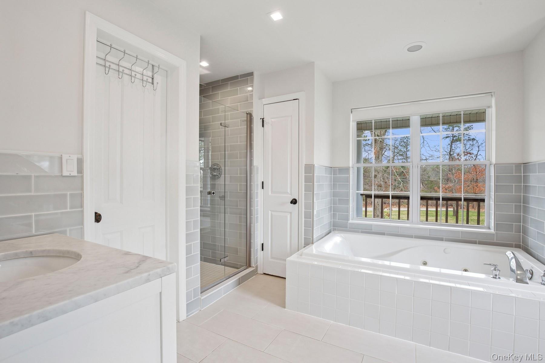 71 Old Canoe Place Road Hampton Bays, NY 11946 - Photo 16 of 34 a bathroom with a bathtub and a sink
