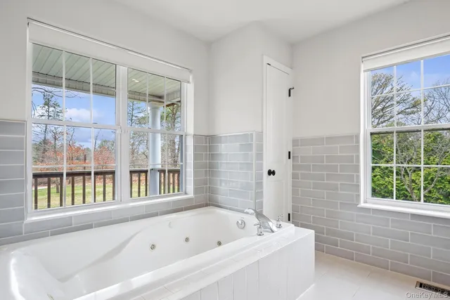 a bathroom with a bathtub and a window