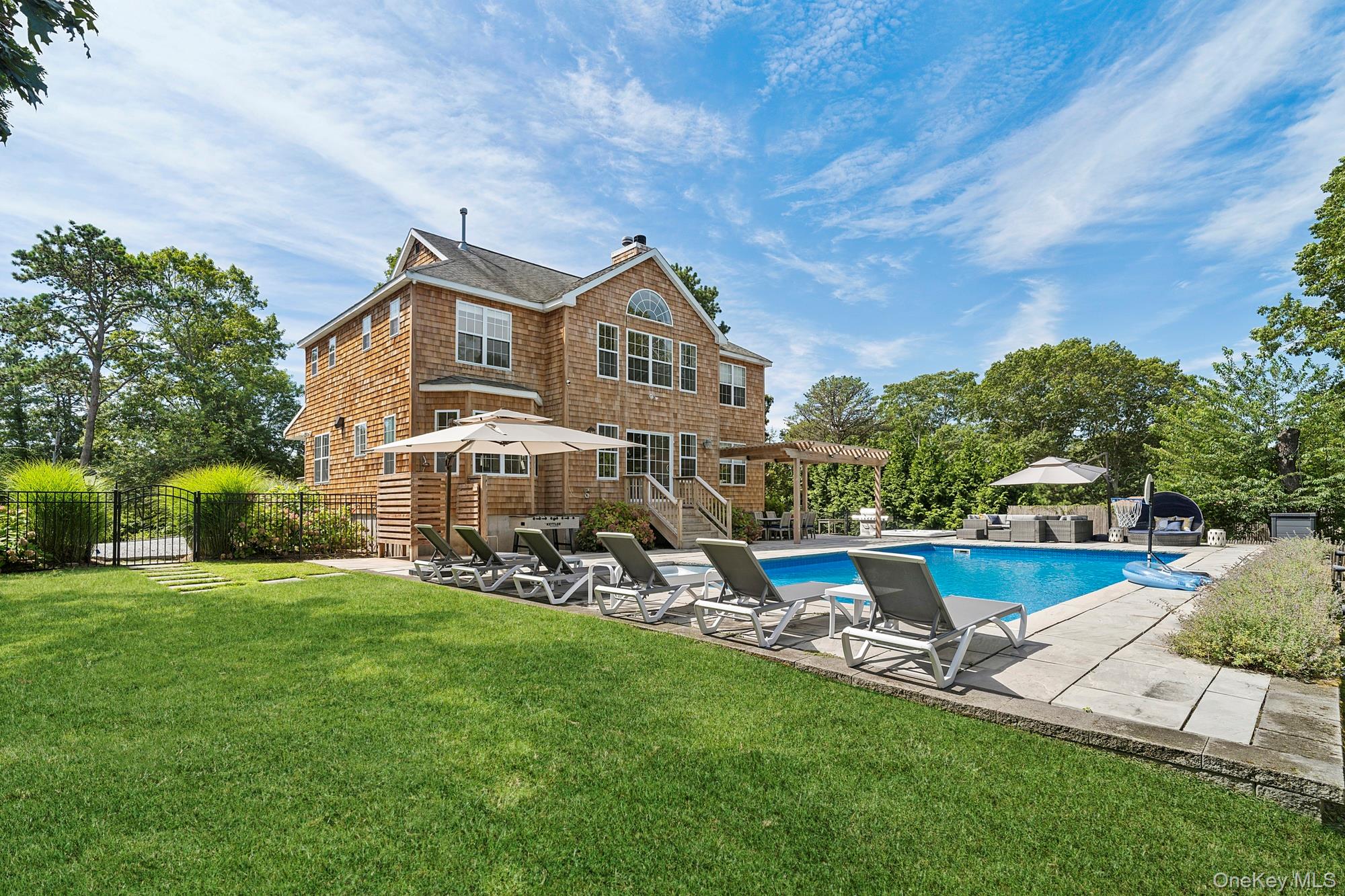 71 Old Canoe Place Road Hampton Bays, NY 11946 - Photo 29 of 34 a front view of a house with a garden and swimming pool