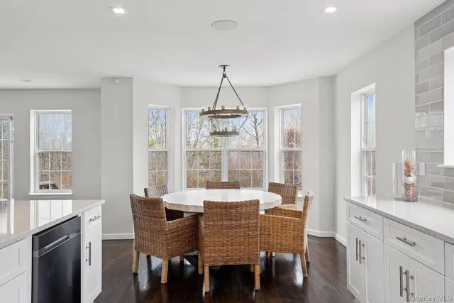 a dining room with furniture a chandelier and wooden floor