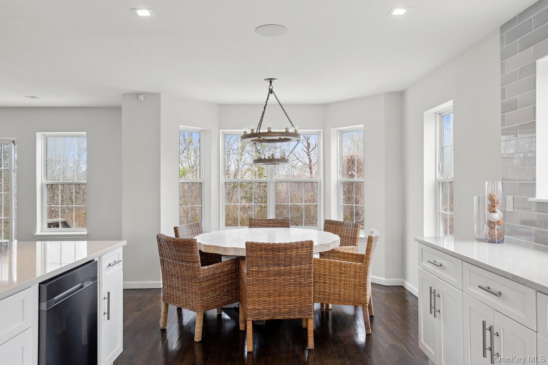 71 Old Canoe Place Road Hampton Bays, NY 11946 - Photo 7 of 34 a dining room with furniture a chandelier and wooden floor