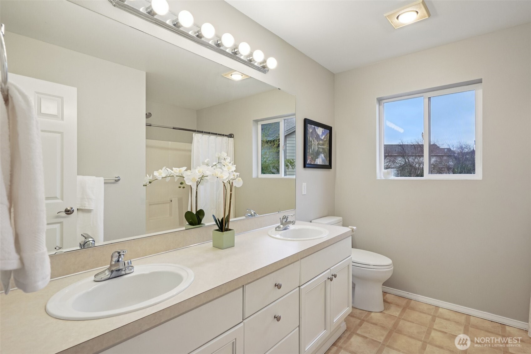 206 Pasco Drive Northeast Renton, WA 98059 - Photo 28 of 40 a bathroom with double vanity sinks a mirror and a lamp