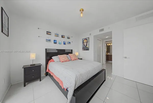 a large bed sitting in a bedroom and painting on the wall