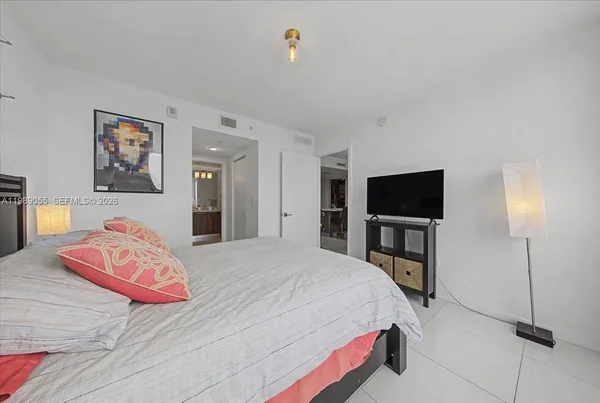 a bedroom with a bed and a flat screen tv