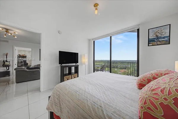 a bedroom with a large bed and a flat tv screen on dresser