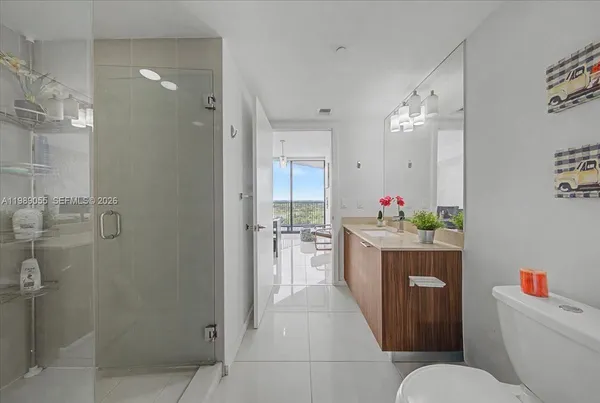 a bathroom with a granite countertop sink mirror vanity and toilet
