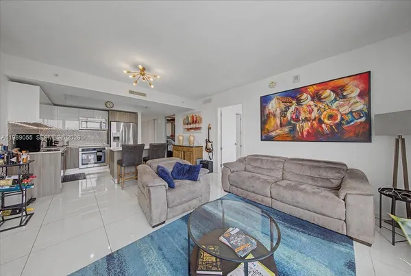 a living room with furniture kitchen view and a window