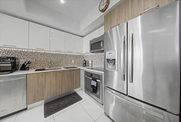 a kitchen with stainless steel appliances a refrigerator sink and microwave