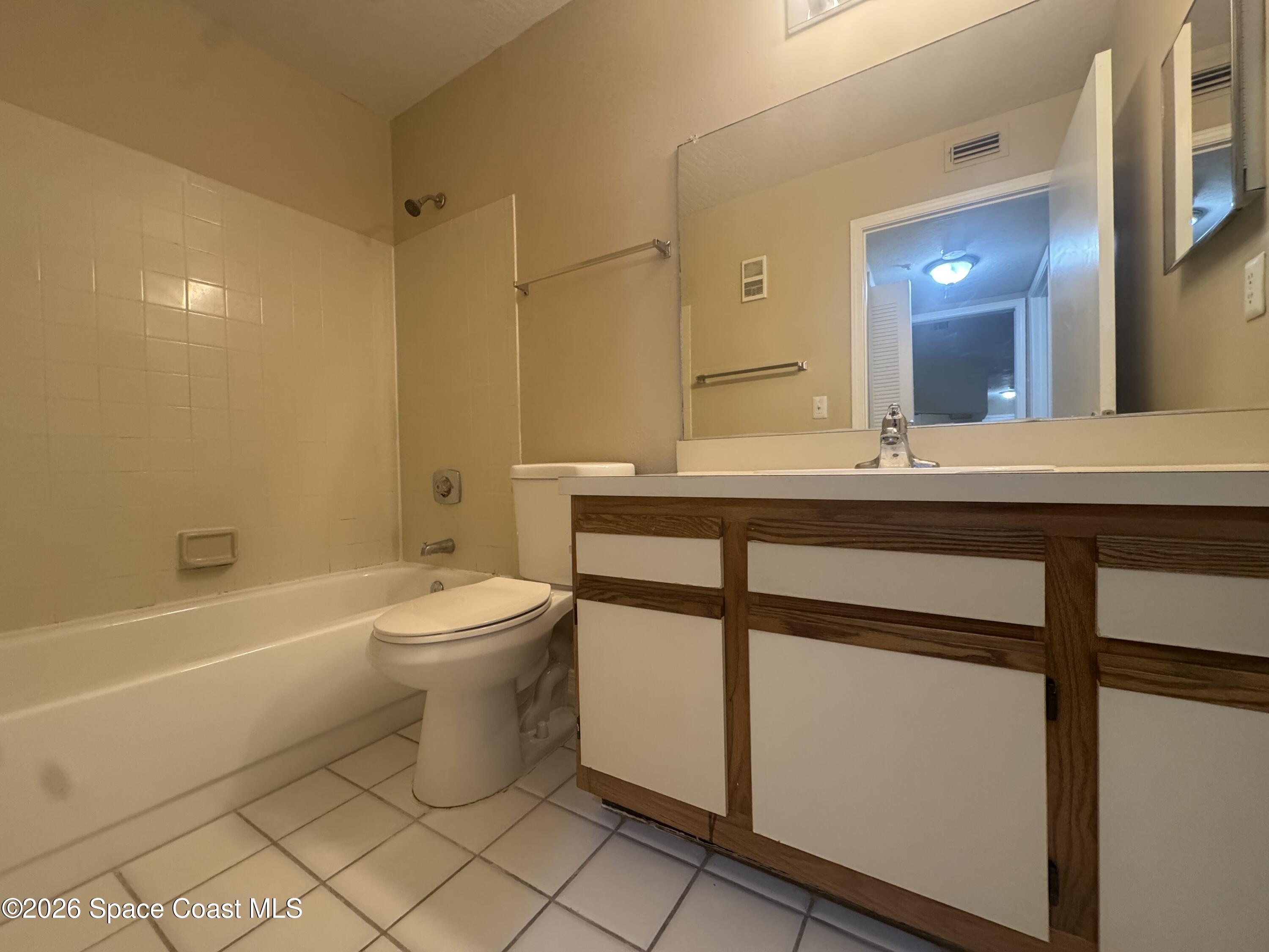 7667 North Wickham Road, Unit 1107 Melbourne, FL 32940 - Photo 12 of 19 a bathroom with a sink a toilet and shower