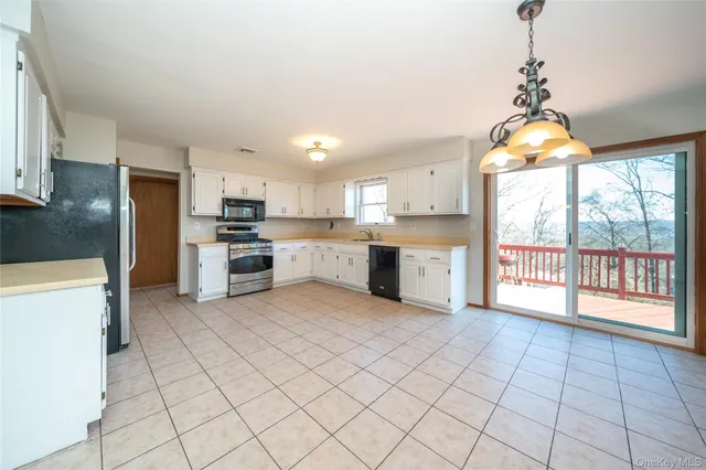 a kitchen with stainless steel appliances granite countertop a stove top oven a sink dishwasher and a refrigerator with wooden floor