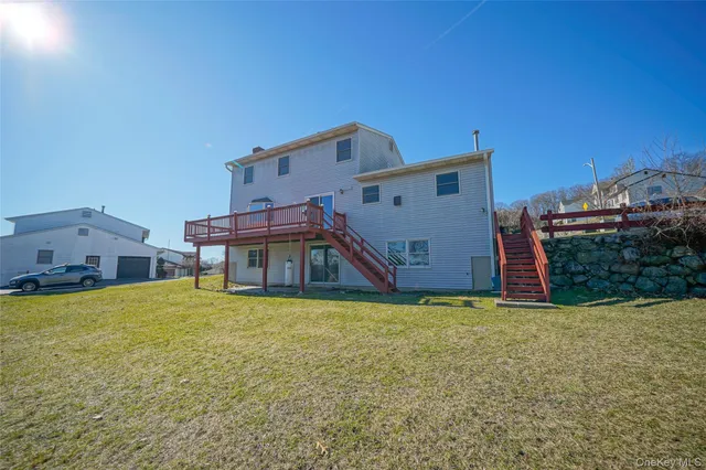 a view of a house with a yard and a large tree