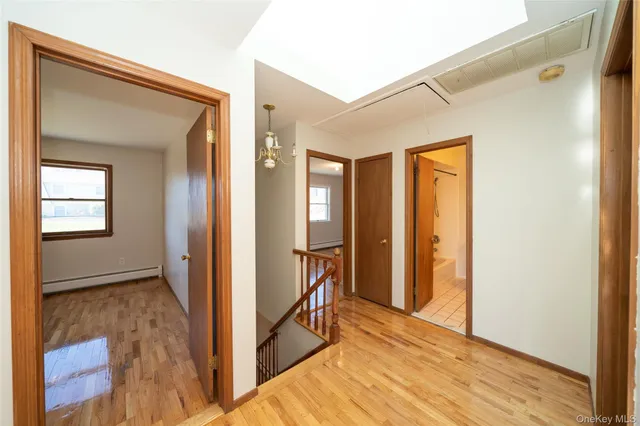 a view of hallway with livingroom and wooden floor