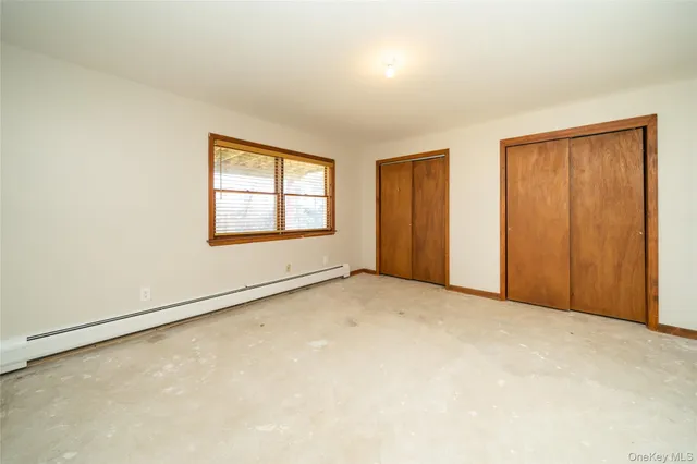 an empty room with windows and closet