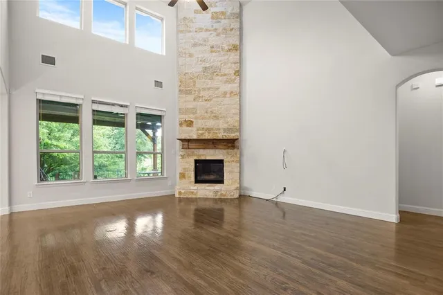 an empty room with wooden floor and a fireplace
