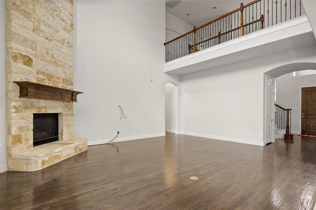 13606 Crianza Road Frisco, TX 75035 - Photo 13 of 40 a view of an empty room with wooden floor and a fireplace