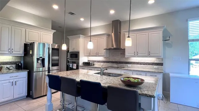 a kitchen with stainless steel appliances granite countertop a sink refrigerator and cabinets