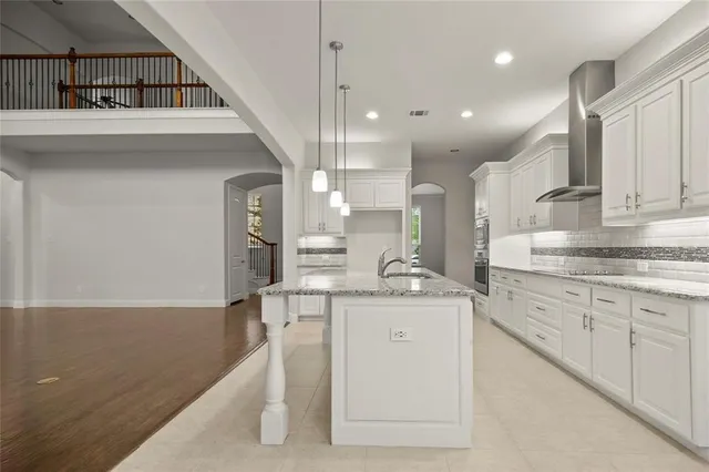 a kitchen with stainless steel appliances granite countertop a sink a stove and a refrigerator