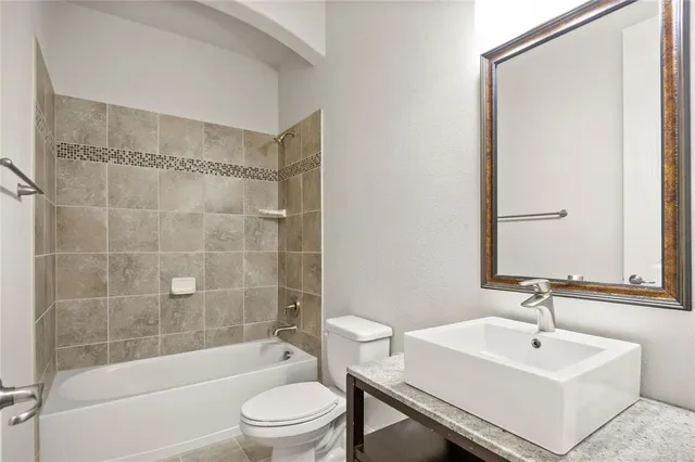 a bathroom with a sink mirror toilet and bathtub