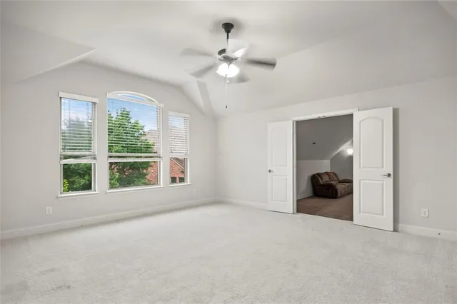 a view of a big room with windows and chandelier fan