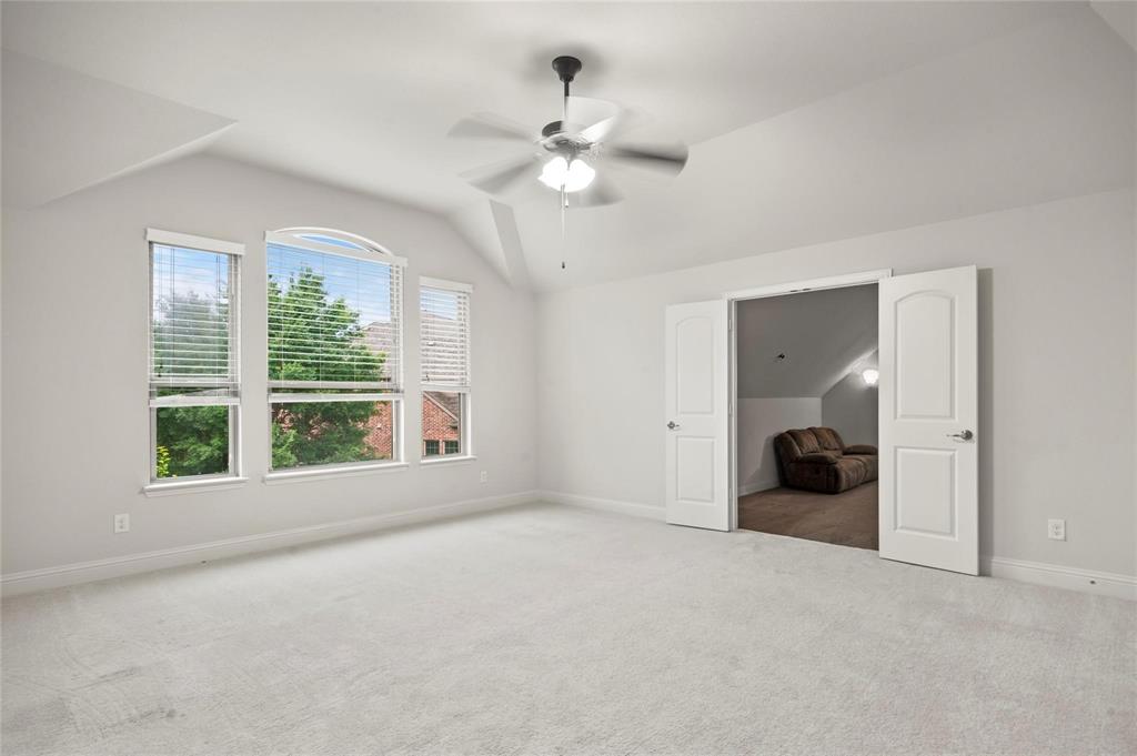 13606 Crianza Road Frisco, TX 75035 - Photo 36 of 40 a view of a big room with windows and chandelier fan