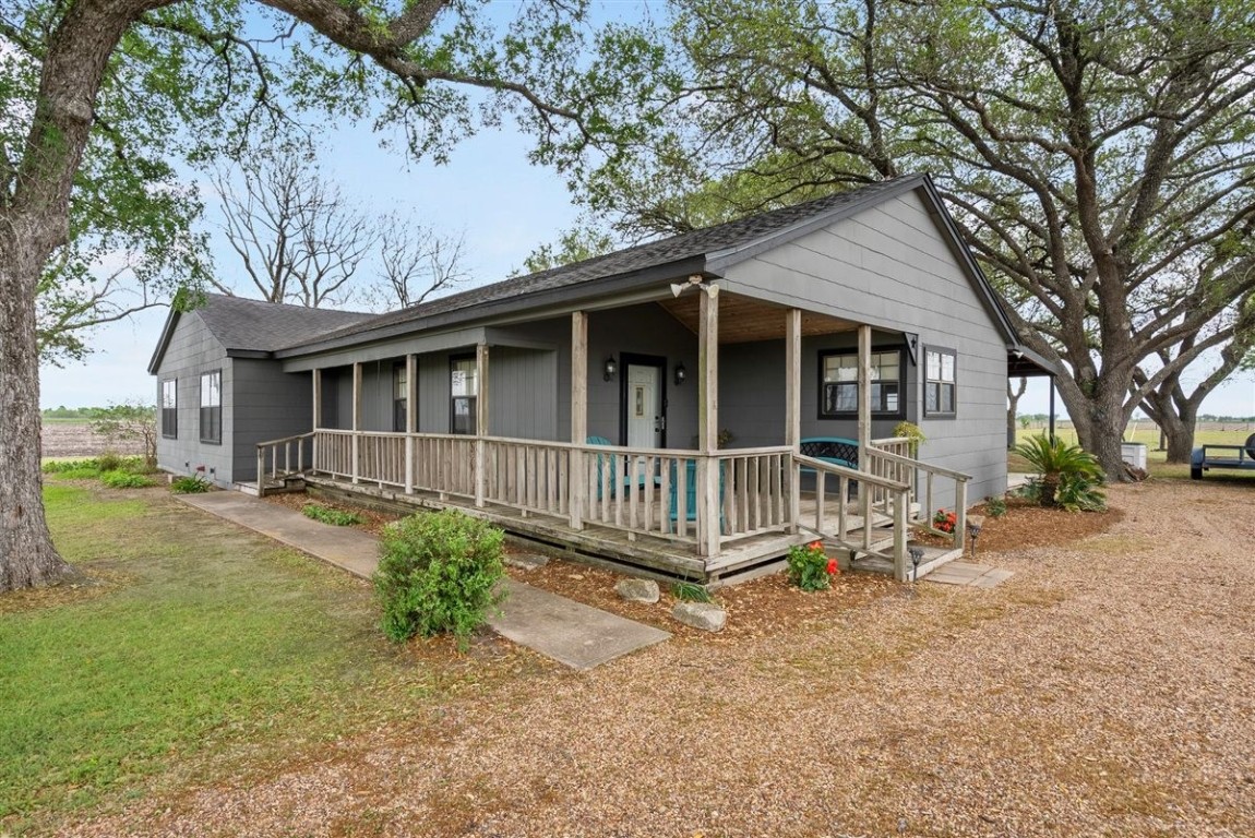 13339 Bj Dusek Road Wallis, TX 77485 - Photo 1 of 39 Charming single-story home with a welcoming front porch, nestled amidst mature trees. The gravel driveway adds rustic appeal, while the lush surroundings offer a serene, countryside feel. Perfect for those seeking a cozy, peaceful retreat.