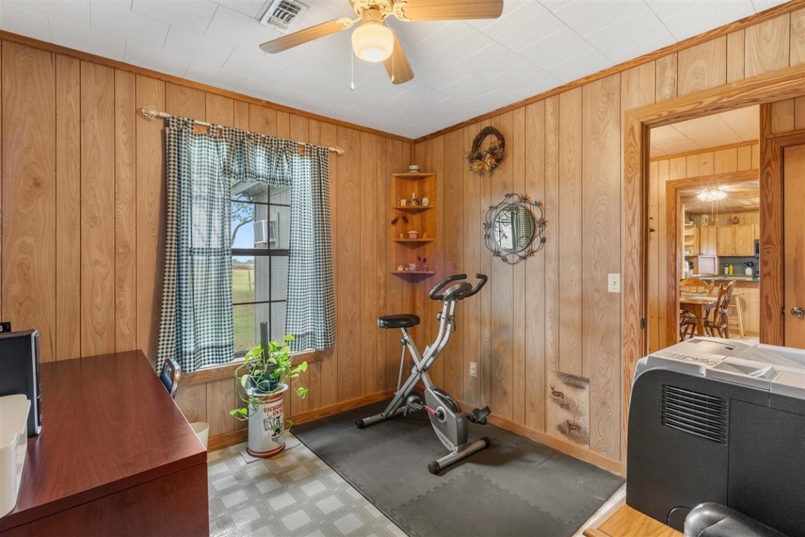 13339 Bj Dusek Road Wallis, TX 77485 - Photo 11 of 39 This cozy room features wood-paneled walls, a ceiling fan, and a window with checkered curtains for natural light. Making it ideal for a home office or gym space.