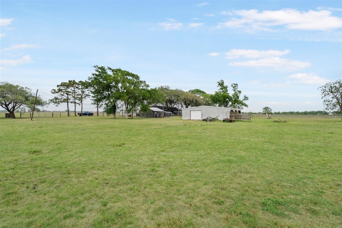 13339 Bj Dusek Road Wallis, TX 77485 - Photo 25 of 39 Expansive, open field with a small outbuilding and scattered trees, perfect for rural living and privacy.