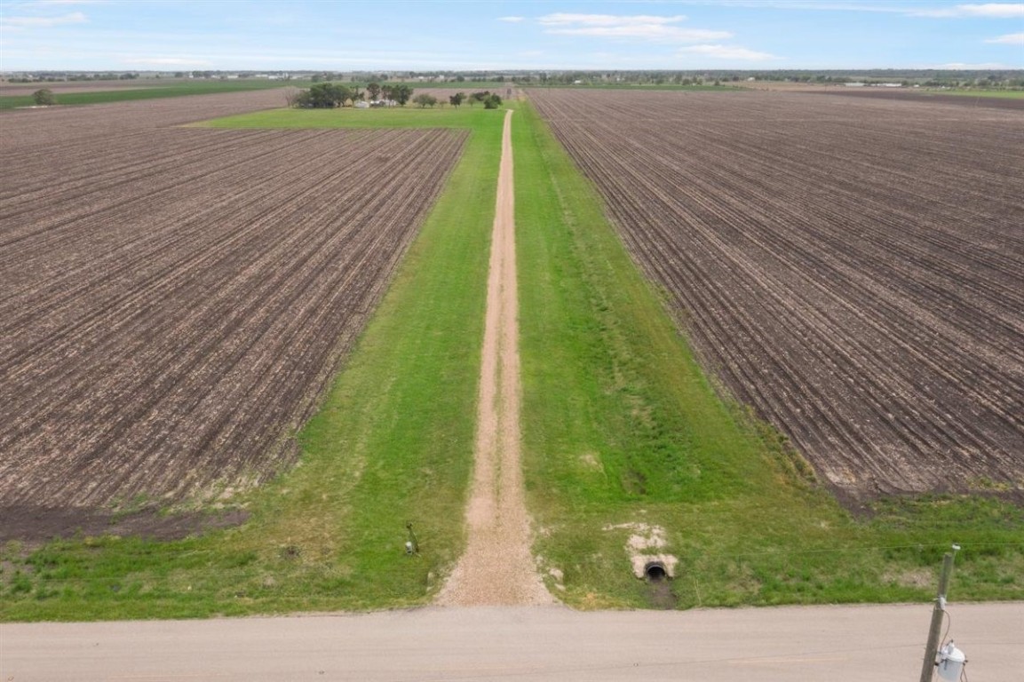 13339 Bj Dusek Road Wallis, TX 77485 - Photo 31 of 39 Expansive agricultural land with a long dirt road leading through fields, offering a vast rural setting and open skies. Ideal for farming or development in a peaceful environment.