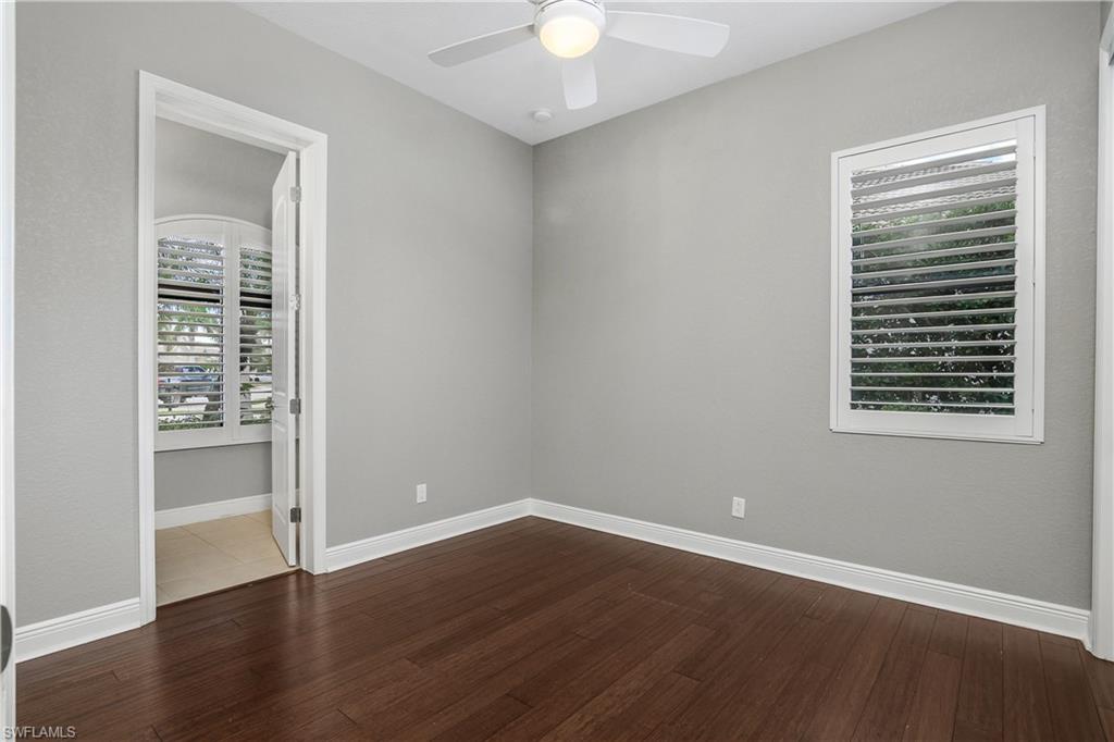 1558 Serrano Circle Naples, FL 34105 - Photo 18 of 31 a view of an empty room with wooden floor and a window