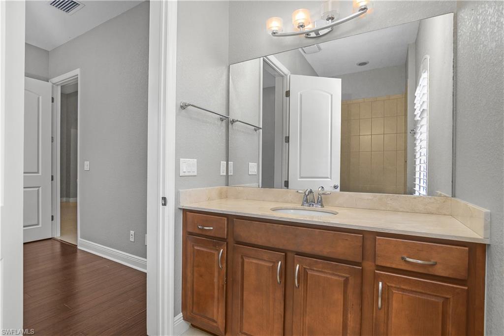 1558 Serrano Circle Naples, FL 34105 - Photo 19 of 31 a bathroom with a granite countertop sink and a mirror