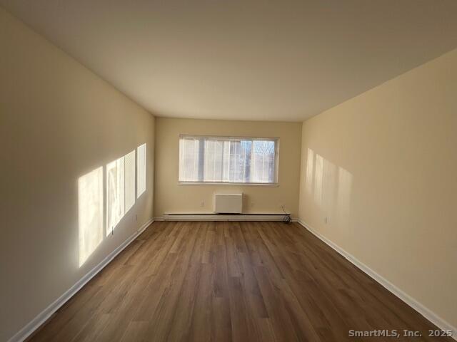 5 West Washington Avenue, Unit 7 Stamford, CT 06902 - Photo 4 of 9 an empty room with wooden floor and windows