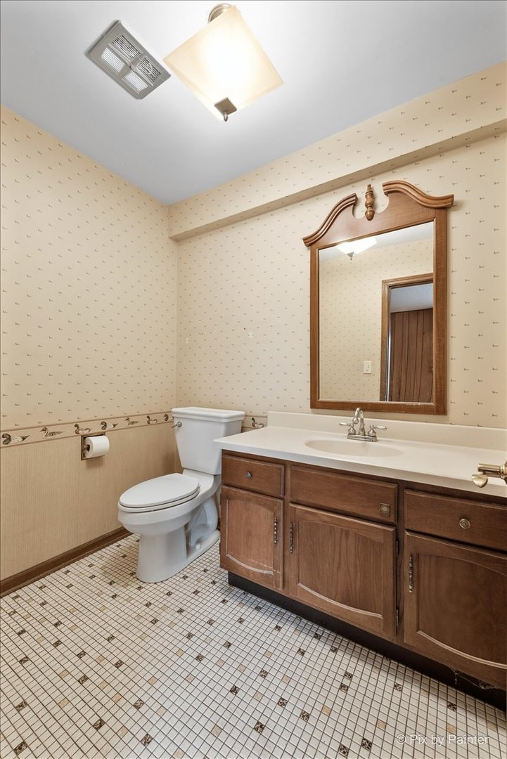 1100 South Church Road Mount Prospect, IL 60056 - Photo 15 of 50 a bathroom with a toilet sink and mirror